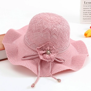Chapeau de soleil en tricot rose à large bord ondulé avec fleur en perles et maille aérée