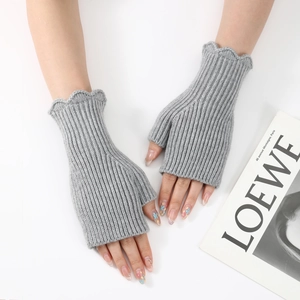 Detail of grey ribbed knit fingerless gloves featuring stylish ruffled lettuce edges