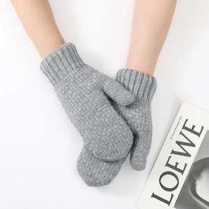 Detail of light grey knit mittens showing the ribbed cuffs and soft wool texture