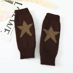 Gros plan détaillé de mitaines en maille marron foncé avec un motif d'étoile beige tissé