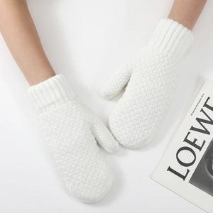 Close-up of white knitted mittens with elastic ribbed cuffs and thick warm texture