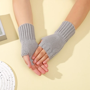 Détail de mitaines en tricot gris montrant les poignets côtelés et l'ouverture du pouce