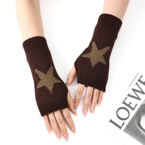 Gros plan de mitaines en tricot avec motif d'étoile et poignets côtelés sur la main