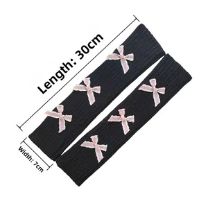 Close-up of black ribbed knit arm warmers with pink bows and detailed 30cm length view