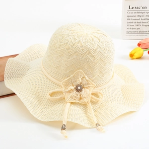 Détail d'un chapeau de soleil en tricot avec fleur au crochet et perles décoratives