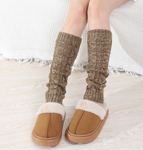 Close-up of thick cable knit leg warmers paired with plush faux fur platform slippers