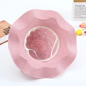 Détail intérieur du chapeau de paille rose avec cordon coupe-vent et texture tissée