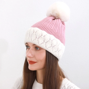 Dettaglio del cappello in maglia rosa con pompon in ecopelliccia e trama traforata fine
