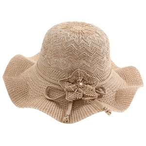 Chapeau de soleil en paille pour femme avec bord ondulé et fleur tressée sur fond blanc
