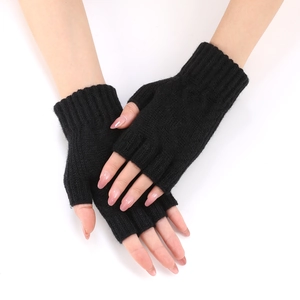 Detail of black knitted fingerless gloves showing the ribbed wrist cuffs and soft texture