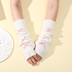 White knit arm warmers featuring pink satin bows and fingerless design in Y2K style