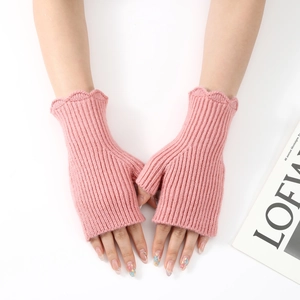 Detail of pink ribbed knit fingerless gloves with elegant wavy ruffled edges for women