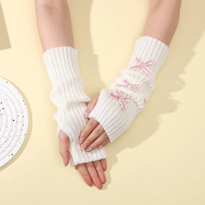 Detailed knit texture of white fingerless arm warmers with cute pink lace bows