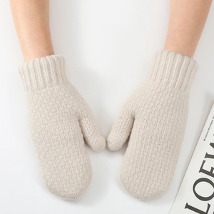 Detailed knit texture of cream thick mittens with elastic ribbed cuffs for winter warmth