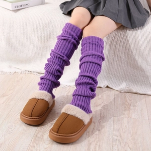 Détail de jambières en tricot violettes avec des chaussons à plateforme en fourrure