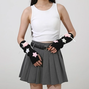 Detail of black Y2K knit arm warmers with plush pink stars and white satin bows