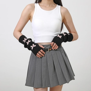 Detail of Y2K knit arm warmers in black with pink satin ribbons and fingerless design