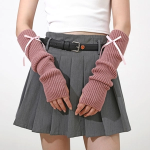 Gros plan de mitaines en tricot rose avec des nœuds en ruban délicats et texture douce
