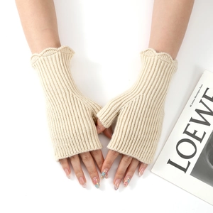 Close-up of cream knitted fingerless gloves with elegant ruffled edges and ribbed texture