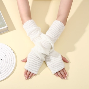 Detailed texture of white ribbed knit arm warmers in a stylish crossed-arm pose