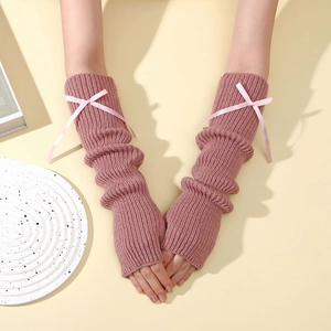 Gros plan de mitaines en tricot rose avec nœuds en soie au style balletcore élégant