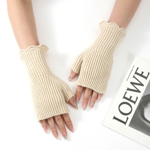 Detail of off-white ribbed knit fingerless gloves with delicate ruffled edges for winter