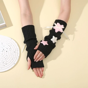 Detail of black knit arm sleeves with pink plush stars and white ribbon bows
