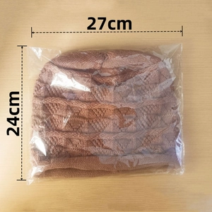 Berretto in maglia marrone steso in piano con dimensioni di 27 cm di larghezza e 24 cm