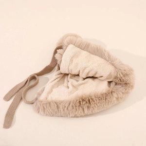 Detail shot of the warm beige plush lining and faux fur texture on the earflap hat