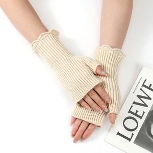 Close-up of off-white knitted fingerless gloves with ruffled edges and ribbed texture