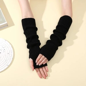 Detail of black knitted thumbhole arm warmers with ribbed texture in a stacked style