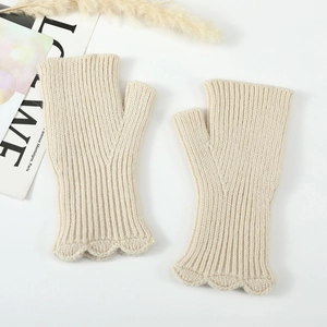 Close-up of cream knit fingerless gloves with ribbed texture and ruffled edge details