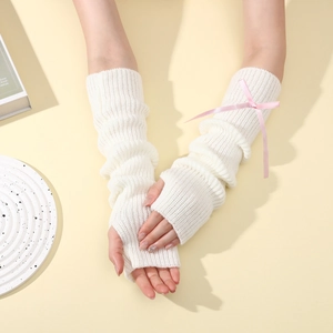 Détail de la maille blanche de mitaines longues avec un nœud en soie rose doux