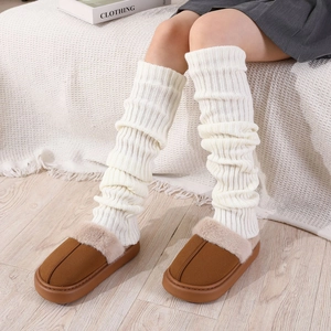 Gros plan de jambières en grosse maille blanche avec chaussons à plateforme en peluche