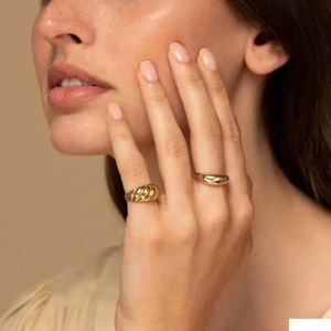 Κοντινό πλάνο με επίχρυσα δαχτυλίδια 18k με υφή κρουασάν και λείο σχήμα θόλου