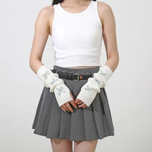 Detail of white ribbed knit arm warmers with blue bow accents for a y2k aesthetic