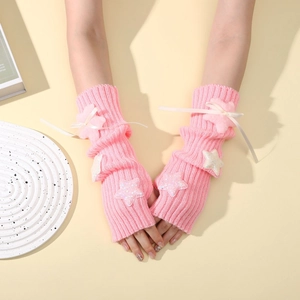 Detail of pink knit arm warmers with plush stars, sequins, and delicate ribbon bows