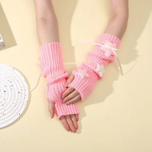 Detailed knit of pink Y2K fingerless arm warmers with plush stars and white ribbons