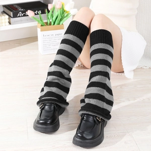 Detail of grey and black striped knit leg warmers paired with platform loafers
