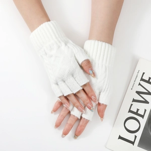 Close-up of white knitted fingerless gloves with cable knit pattern and ribbed cuff detail