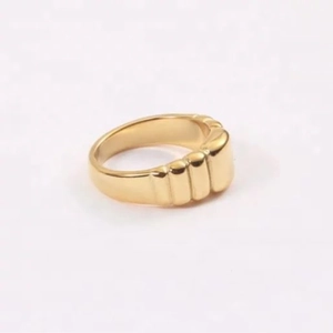 Macro dell'anello a croissant dorato con dettagli a costine e finitura in metallo lucido
