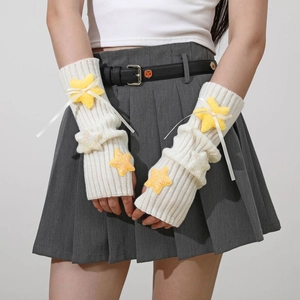 Close-up of white ribbed knit arm warmers featuring plush yellow stars and ribbon bows