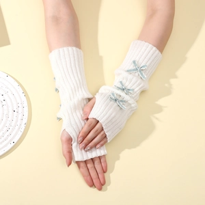 Detail of white knit fingerless gloves with blue ribbon bows and y2k style texture
