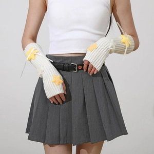 Detail of cream knit arm warmers with plush yellow stars and delicate white bows