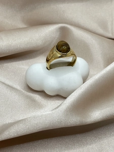 Makro-Detail des 18k vergoldeten Rings mit ovalem braunem Achatstein auf Seidenhintergrund