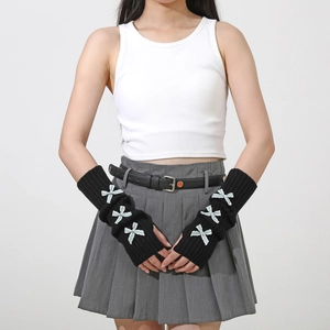 Detail of black knitted arm warmers with light blue satin bows in Y2K aesthetic style