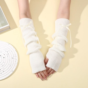 Détail de mitaines en tricot blanc à côtes avec un élégant nœud en soie décoratif