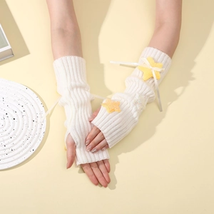 Detail of cream knit arm warmers with yellow sequin star and beige ribbon bow accents