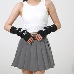 Detailed knit texture of black arm warmer featuring light blue satin ribbon bows
