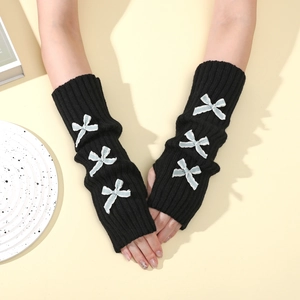 Detail of black knit arm warmers with blue bow accents and fingerless coquette design